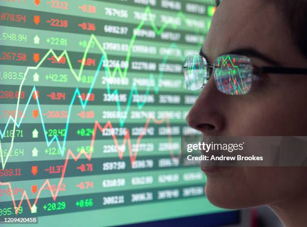 female analyst viewing financial market data on a screen. - capitalismo foto e immagini stock