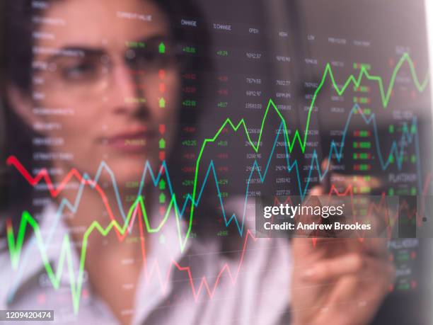 female analyst viewing financial market data on a screen. - traders photos et images de collection