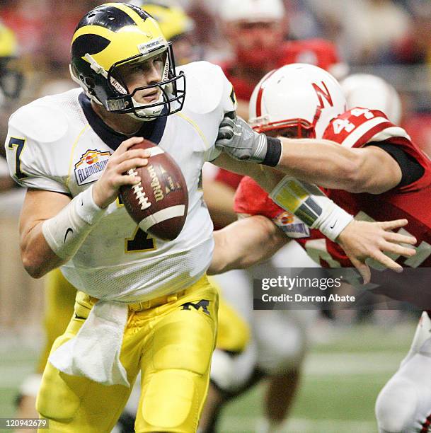 Michigan quarterback Chad Henne evades Nebraska's Jay Moore during the 2005 MasterCard Alamo Bowl game game between the University of Michigan...