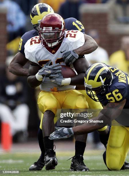 Minnesota's Laurence Maroney gets tackled by Michigan's LaMarr Woodley and Willis Barringer at Michigan Stadium on October 8, 2005 in Ann Arbor,...