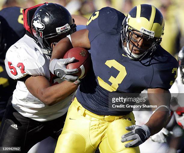 University of Michigans Kevin Grady tries to break the tackle of Northern Illinois Dallas Bassett at Michigan Stadium on September 3, 2005. Michigan...