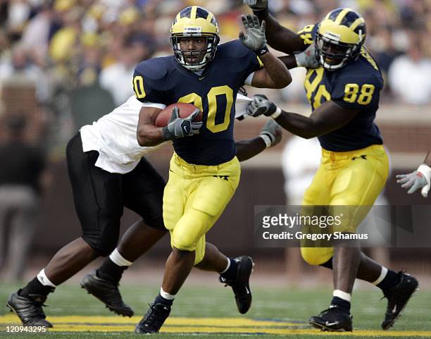 University of Michigans Mike Hart looks for running room after a block by Tim Massaquoi against Northern Illinois at Michigan Stadium on September 3,...
