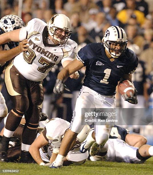 Running back Fui Vakapuna runs past Wyoming defender Jake Mayes at LaVell Edwards Stadium in Provo, Utah, Thursday Nov. 11, 2006. BYU defeated...