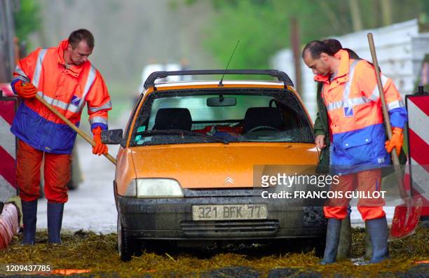 Deux hommes désinfectent une voiture dans un rotoluve, le 24 mars 2001, à l'exploitation agricole de de Mitry-Mory où un cas de fièvre aphteuse a été...