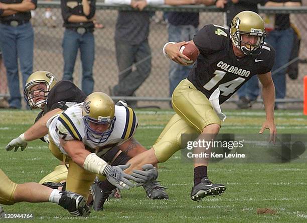 University of Colorado quarterback Joel Klatt eludes the tackle of UCLA defensive tackle Rodney Leisle during the third quarter Saturday Sept. 6,...
