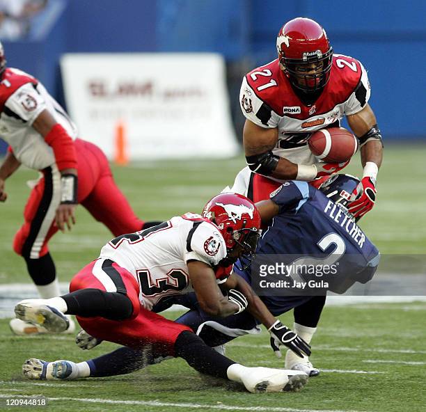 Calgary Stampeders Running Back Joffrey Reynolds nearly fumbles while being tackled by Toronto's Michael Fletcher at Rogers Centre in Toronto, Canada...
