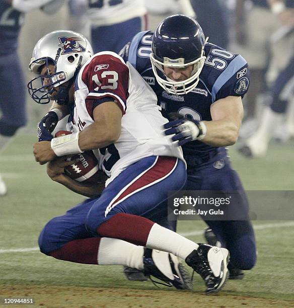 Anthony Calvillo of the Montreal Alouettes is sacked by Toronto Argonaut linebacker Mike O'Shea in Canadian Football League action at Rogers Centre...