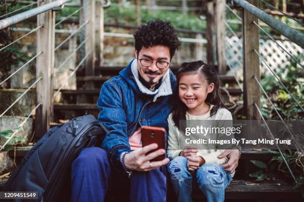 dad & daughter taking selfies joyfully in country park - father and daughter looking at smartphone together stock pictures, royalty-free photos & images