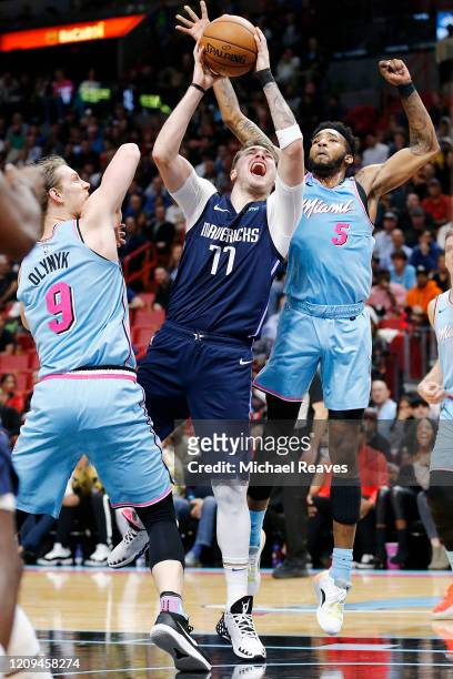 Luka Doncic of the Dallas Mavericks drives to the basket against Kelly Olynyk and Derrick Jones Jr. #5 of the Miami Heat during the first half at...