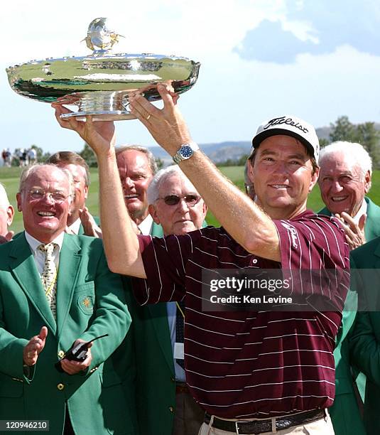 Davis Love III holds aloft the trophy for winning the International at Castle Pines, Colorado, by a 12 point margin. Behind Love are members of the...