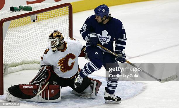 Calgary Flames goaltender Mikka Kiprusoff makes a save as Toronto Maple Leaf forward Darcy Tucker provides a screen in action at the Air Canada...