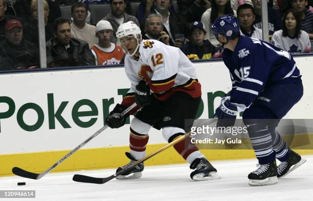 Calgary Flames forward Jarome Iginla looks to elude the checking of Toronto Maple Leaf defenceman Tomas Kaberle in action at the Air Canada Centre in...