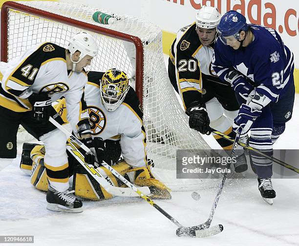 Boston Bruins Andrew Alberts and Wayne Primeau battle for the puck with Toronto's Alexei Ponikarovsky as Boston goaltender Tim Thomas hugs the goal...