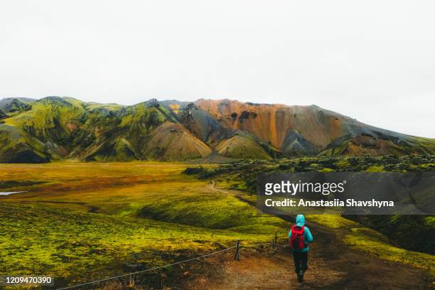 woman hiker exploring the scenic colorful mountain landscape in iceland - horizon over land stock pictures, royalty-free photos & images