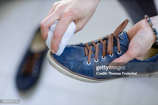 Berlin, Germany Symbolic image on the subject of shoe cleaning. A woman polishes a pair of shoes with a cloth on April 05, 2020 in Berlin, Germany.