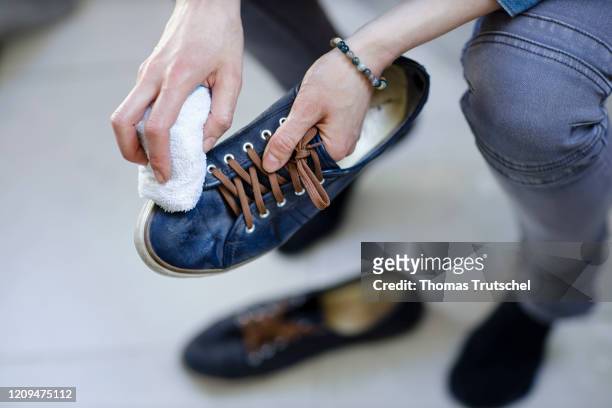 Berlin, Germany Symbolic image on the subject of shoe cleaning. A woman polishes a pair of shoes with a cloth on April 05, 2020 in Berlin, Germany.