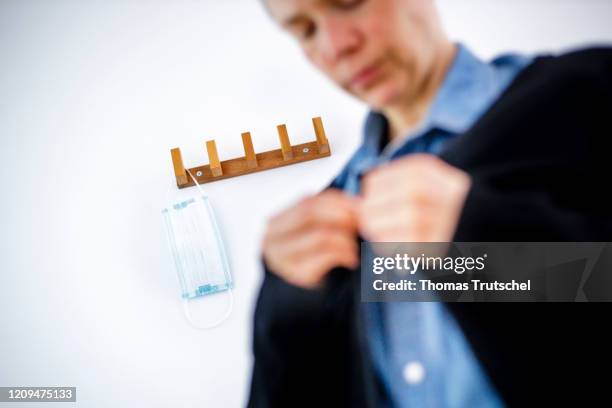 Berlin, Germany Symbolic image on the subject of the containment of the coronavirus, COVID-19, SARS-CoV-2. A mouth guard hangs from a coat rack. In...