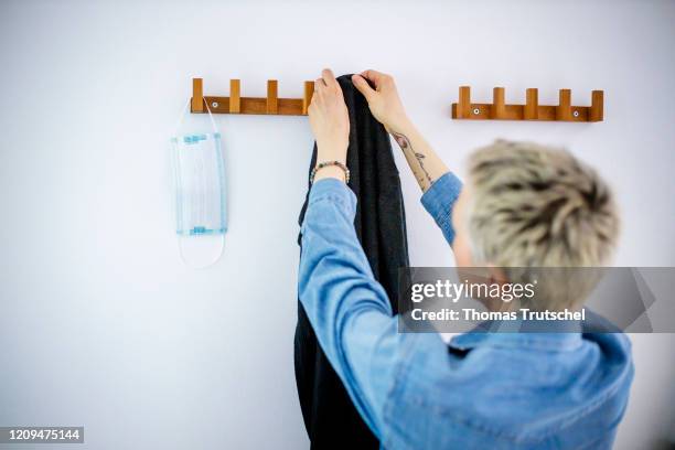 Berlin, Germany Symbolic image on the subject of the containment of the coronavirus, COVID-19, SARS-CoV-2. A mouth guard hangs from a coat rack. A...