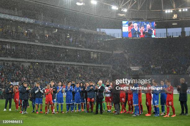 Karl-Heinz Rummenigge and Dietmar Hopp come together with players to applaud the home fans after demonstrations after the Bundesliga match between...