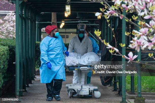 Kingsbrook Jewish Medical Center employees transport a deceased patient to a refrigerated truck on April 8, 2020 in the Brooklyn borough of New York...