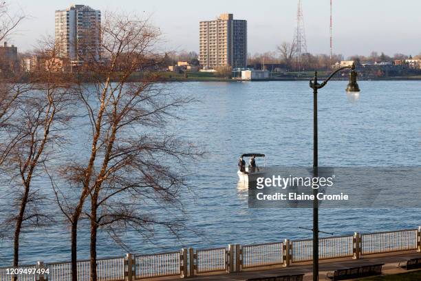 Two people fish from a boat on the Detroit River across from Windsor, Ontario, Canada on April 8, 2020 in Detroit, Michigan. In an effort to slow the...