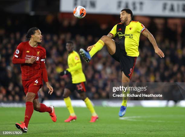 Troy Deeney of Watford challenges Virgil van Dijk of Liverpool during the Premier League match between Watford FC and Liverpool FC at Vicarage Road...