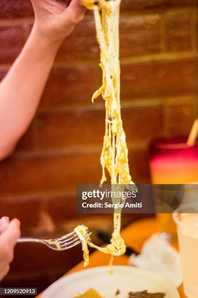 pulling cheese string from mexican alambre with arrachera - 線を引く ストックフォトと画像