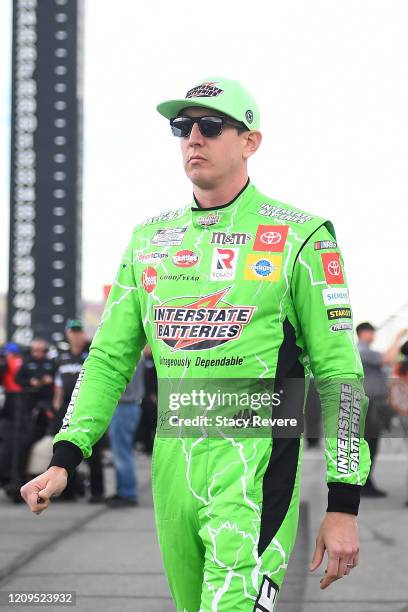 Kyle Busch, driver of the Interstate Batteries Toyota, walks to his car during qualifying for the NASCAR Cup Series Auto Club 400 at Auto Club...