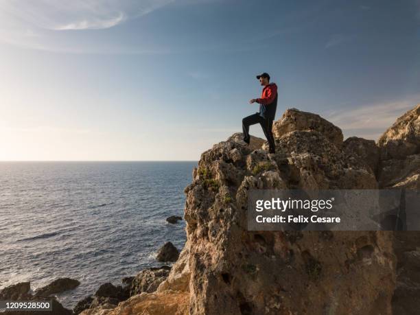 a young man exploring the west coast of malta - malta wandern stock-fotos und bilder