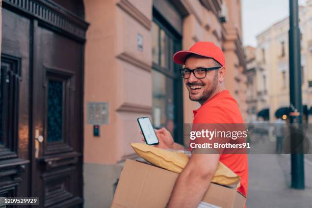 corriere che utilizza un telefono cellulare - berretto da uniforme foto e immagini stock