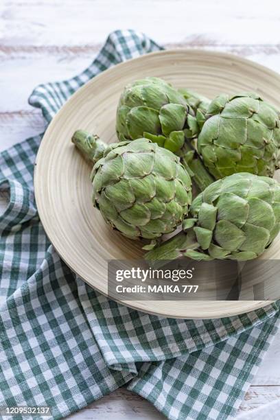 high angle view of artichokes on bamboo bowl - high fibre diet stock pictures, royalty-free photos & images