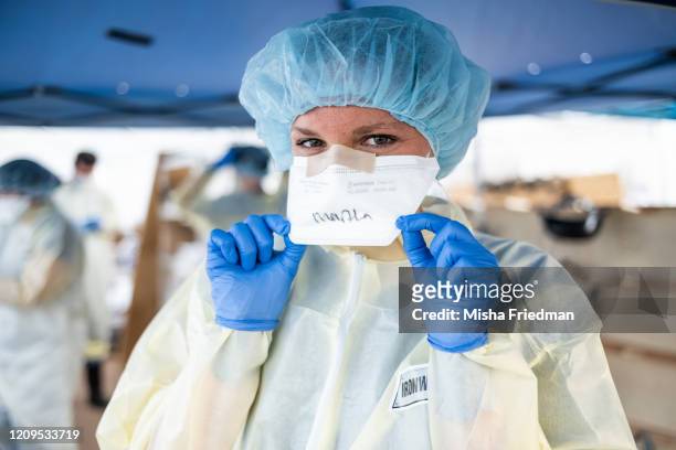 April 08: Medical workers write their names on face masks to identify each other while wearing PPEs at the emergency field hospital run by...