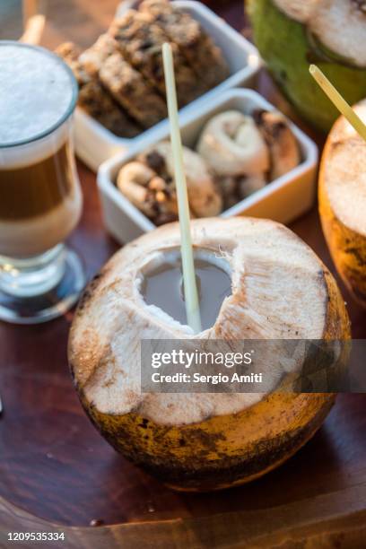open coconut with straw - coconut water stock pictures, royalty-free photos & images