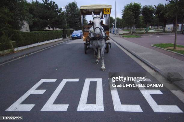 Une voiture hippomobile tirée par une jument percheronne, Pola de Nesque, amène un groupe d'enfants à l'école, le 29 septembre 2006 à...