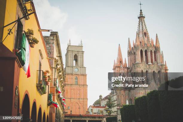 downtown san miguel de allende, gto. mexico showing the cathedral.  september 2019. streets decorated with mexican flags. - león mexique photos et images de collection