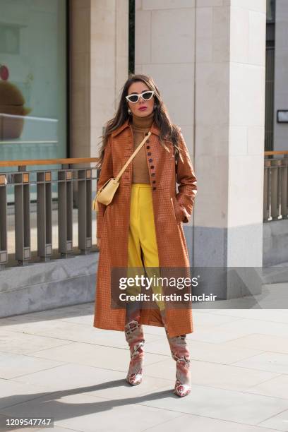 Jewellery designer and digital influencer Nurce Erben wears Aquazzura boots, Topshop coat, Furla bag, Céline sunglasses, Topshop trousers and Zara...