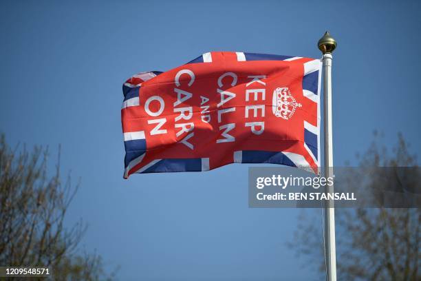 Keep Calm and Carry On flag flies in the garden of a home in Bodiam, southern England, on April 9, 2020 as Britain continued to battle the outbreak...