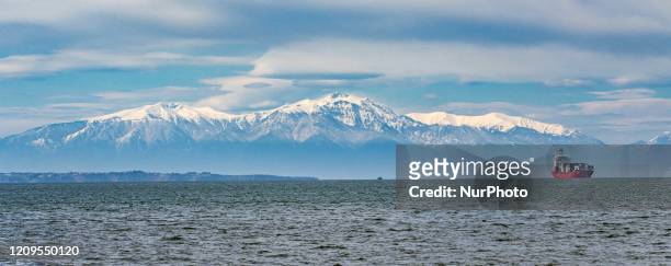 Snow-covered Mount Olympus as seen from Thessaloniki city in Greece after the rare weather and the April snowfall, the mountain is behind the sea,...