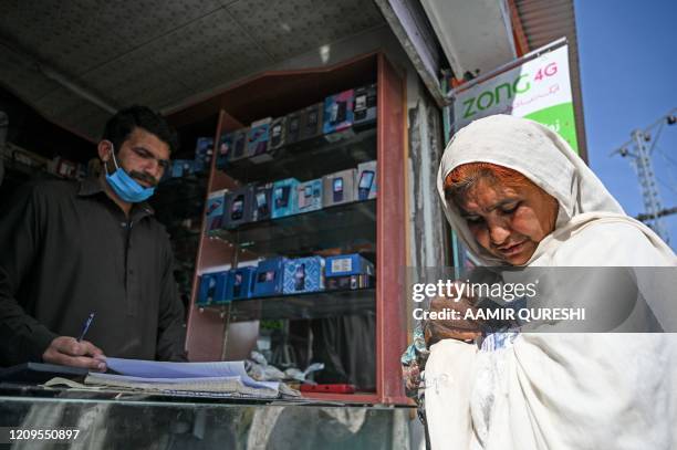 Woman counts rupee notes after collecting cash of financial assistance through a mobile wallet under the governmental Ehsaas Emergency Cash Programme...