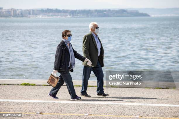 People as seen wearing face masks and gloves as protective measure against Covid-19 Coronavirus Pandemic, while walking along the seafront promenade...