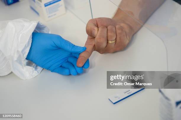 Health worker wears a protective mask and suit as she extracts blood from a patient to perform an antibody test for COVID-19 at the Dworska Hospital...