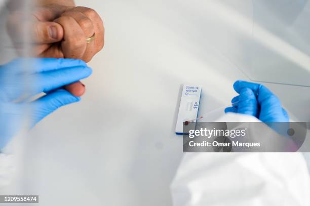 Health worker wears a protective mask and suit as she extracts blood from a patient to perform an antibody test for COVID-19 at the Dworska Hospital...