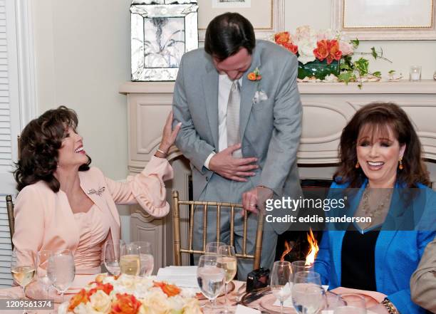 Joan Collins shares a joke with her husband Percy Gibson and sister Jackie Collins at the reception after renewing her wedding vows at the Hotel Bel...