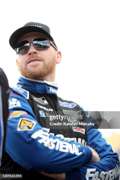 Chris Buescher, driver of the Fastenal Ford, stands by his car before qualifying for the NASCAR Cup Series Auto Club 400 at Auto Club Speedway on...