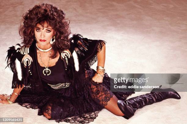 British Actress Joan Collins poses on the living room floor in her Bowmont Dr, Beverly Hills, California home in September 1985. Joan is wearing a...