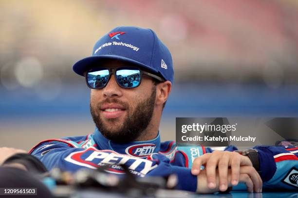 Bubba Wallace, driver of the Victory Junction Chevrolet, stands by his car before qualifying for the NASCAR Cup Series Auto Club 400 at Auto Club...