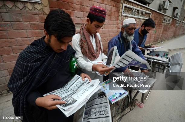 People are reading the newspapers at a cyclist's mobile cycle newspaper stall.