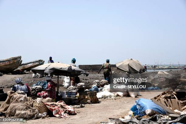 Women walk past stalls at the deserted fish market in Rufisque on APril 9, 2020. - The World Bank warned Thursday sub-Saharan Africa could slip into...