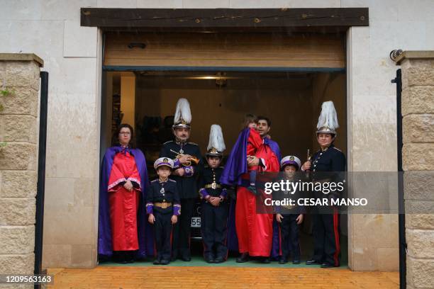 Members of the Rodriguez and Juez families pose at their garage dressed up in their Easter brotherhoods clothes in Burgos, northern Spain, on April 9...