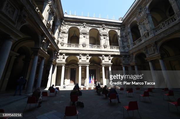 Journalists wear protective masks and keep their social distance during the press conference on the measures taken for cornavirus in the courtyard of...